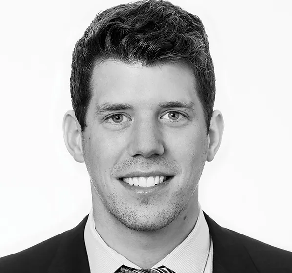 a black and white photo of a man wearing a suit and tie