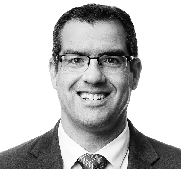a black and white photo of a man wearing a suit and tie